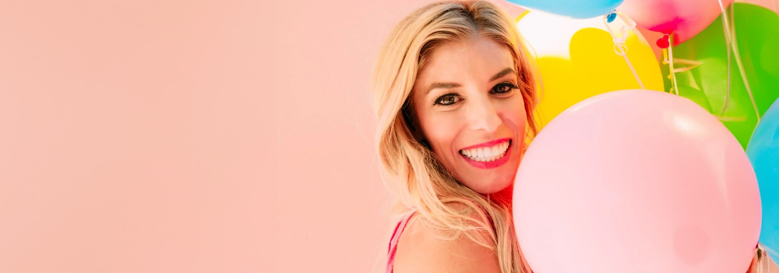 Rebecca Zamolo smiling and holding balloons. 