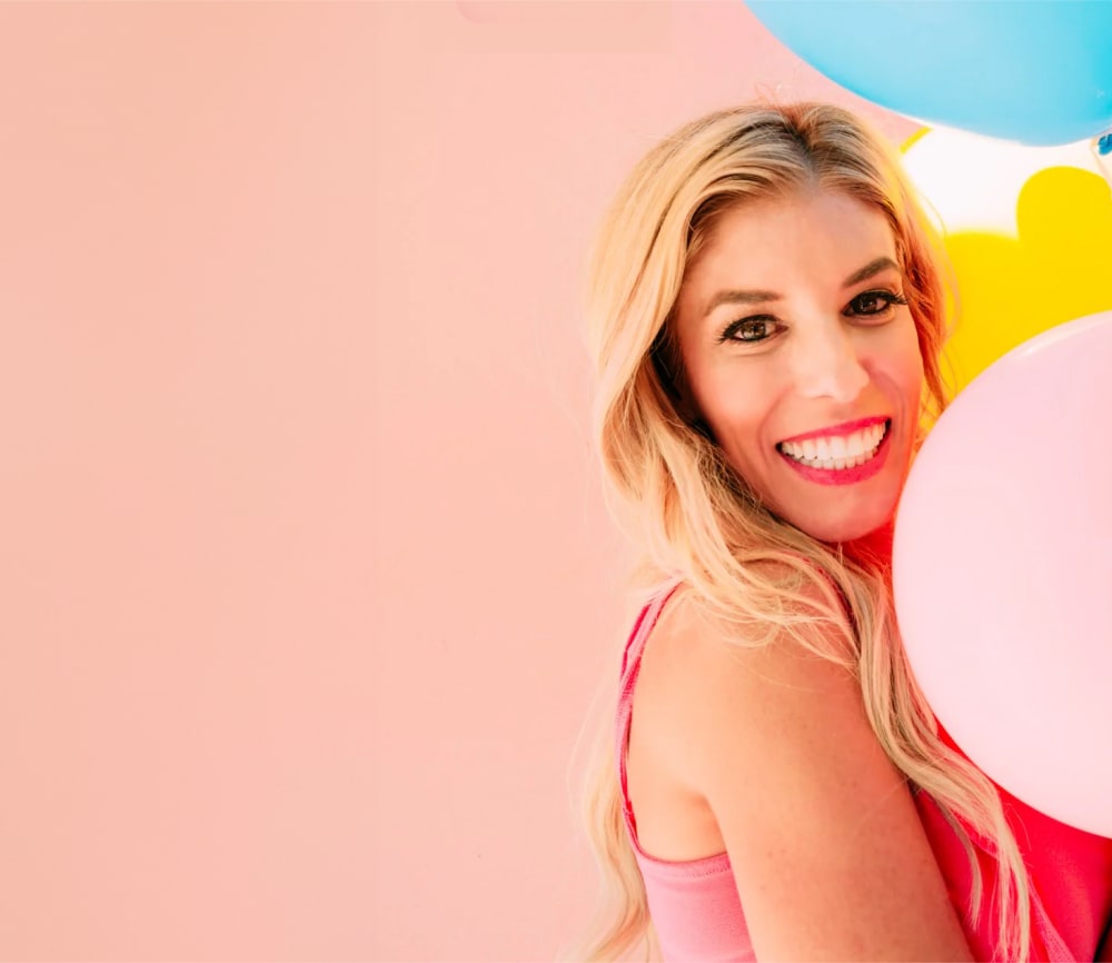 Rebecca Zamolo smiling and holding balloons. 