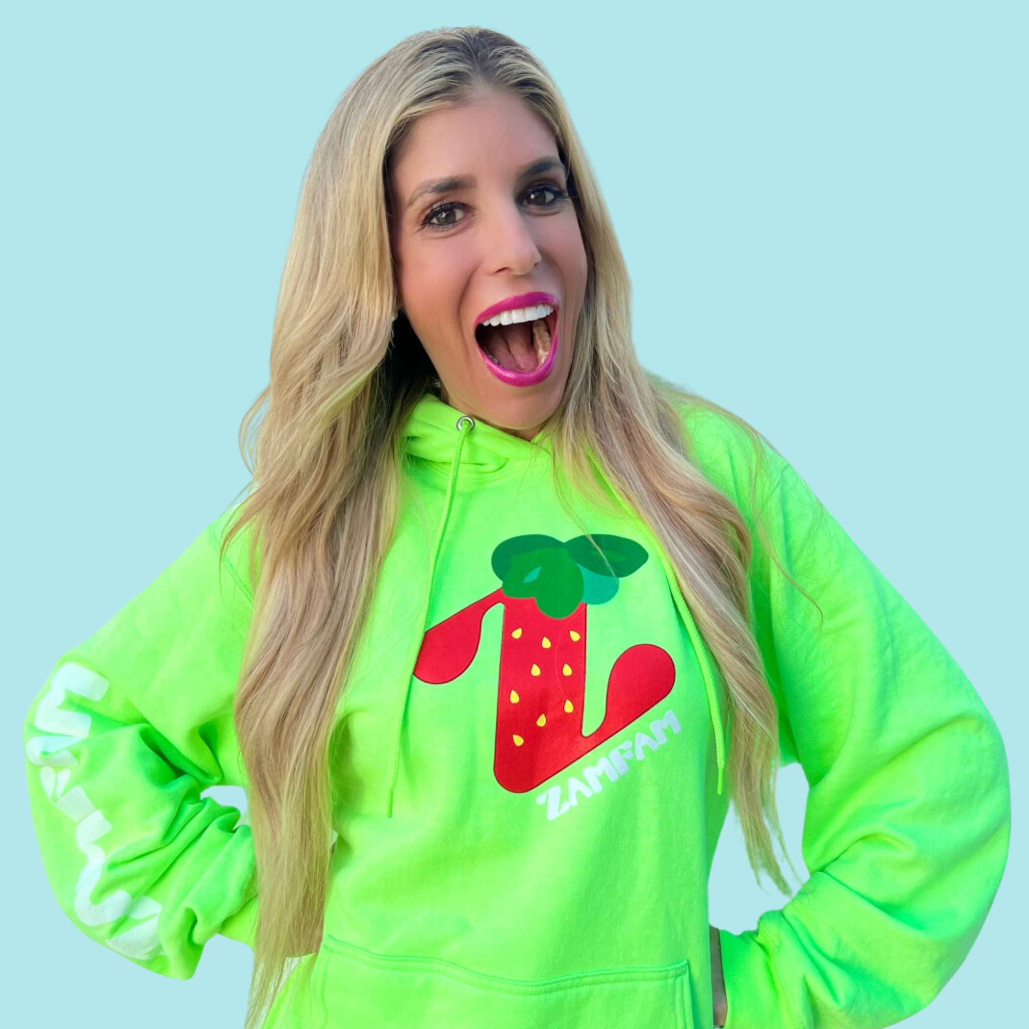 Rebecca Zamolo wearing the green strawberry Zamfam hoodie.