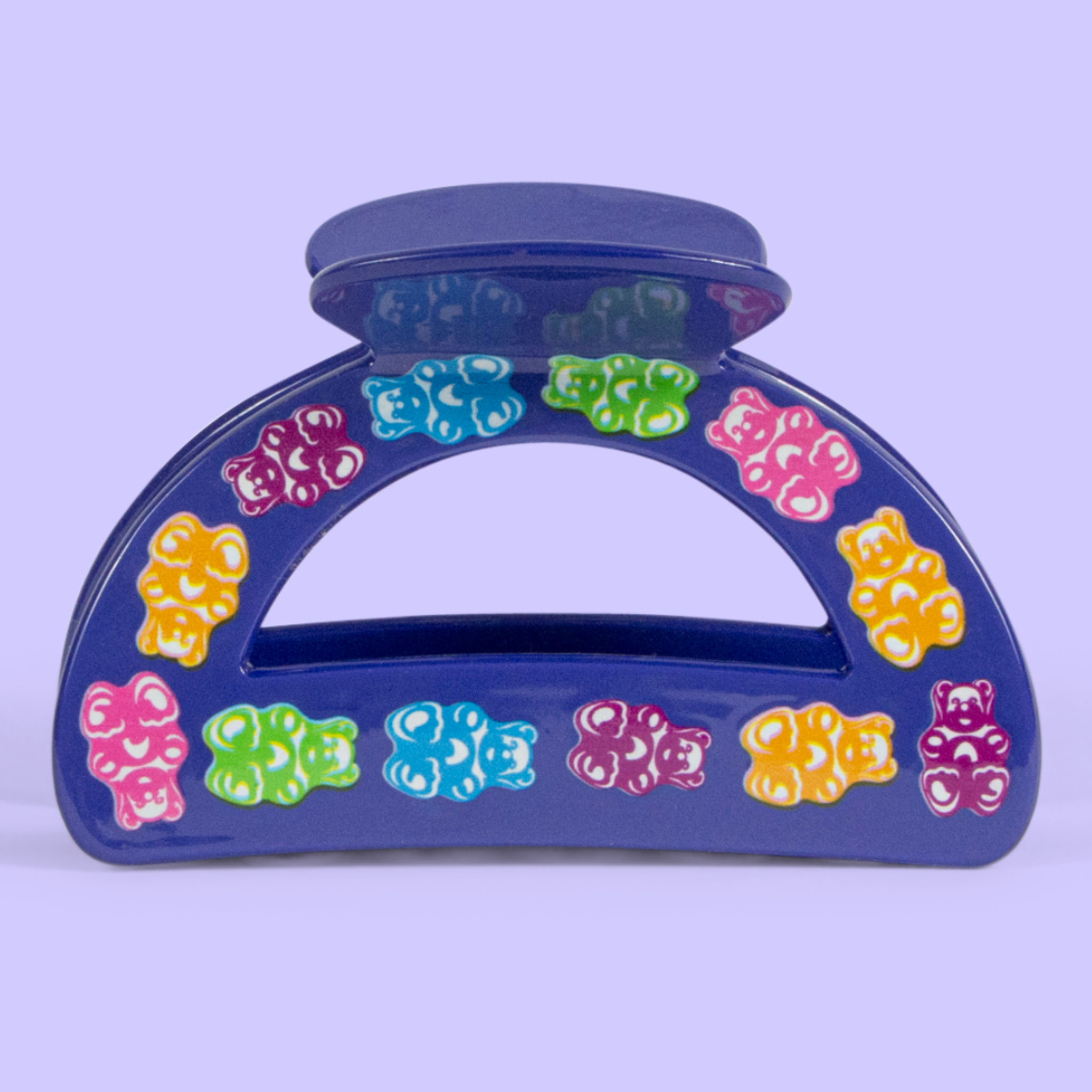 Close up of a purple hair clip with gummy bear designs.